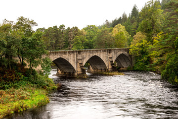 Fototapeta na wymiar A bridge over River Oich next to the swing bridge and historic Bridge of Oich at Aberchalder, Scottish Highlands