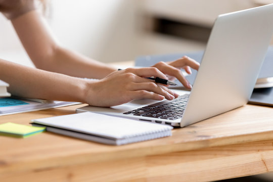 Closeup cropped image student girl hands typing using laptop