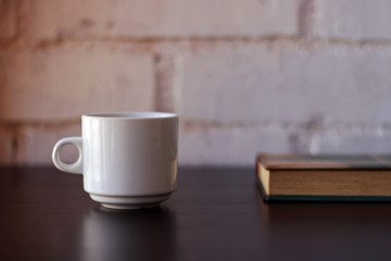 Cup of coffee next to a book.