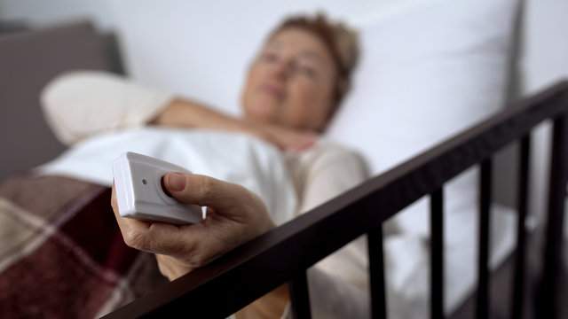 Female patient pressing nurse call button losing consciousness, hospital service