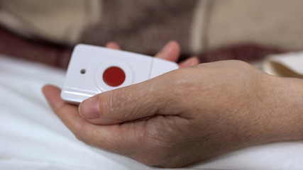 Sick woman hand holding nurse call button, medical service in clinic, technology