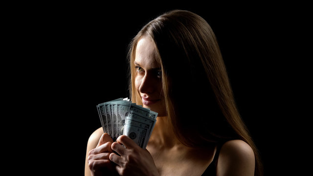 Greedy woman holding dollar banknotes, love for money, illegal income, escort