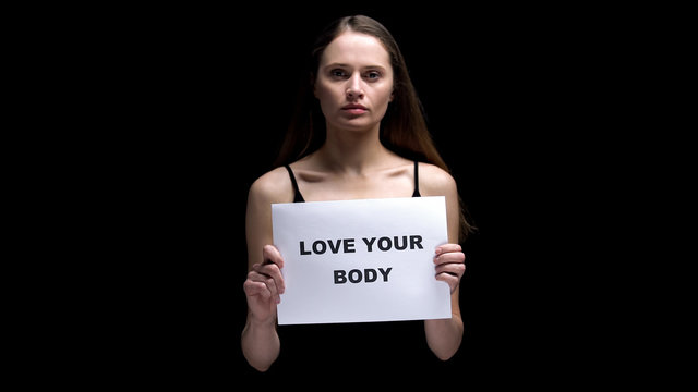 Woman showing love your body sign, accepting individuality as beauty, freedom