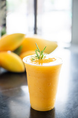 Summer smoothie Menu a Mango juice in plastic glass.