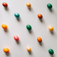 Small multi-colored Easter eggs on the kulich, festively decorated with colorful painted eggs paint, background