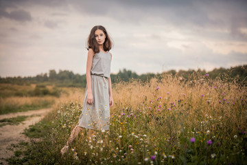 girl walks in the field on a summer evening