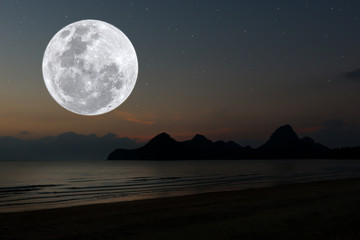 Full moon over sea at night.