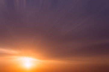 Abstract dramatic dark sunset with bright sunshine and dark clouds.