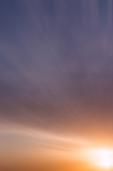 Abstract sunset on the summer sky with beautiful clouds against the blue sky.