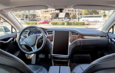 Interior of a modern electric car on a sunny day. the city is blurred in the background