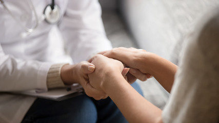 Close up horizontal image doctor holding hands of female patient - Powered by Adobe