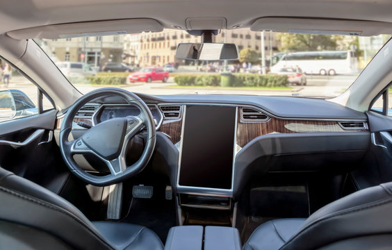 Interior of a modern electric car on a sunny day. the city is blurred in the background