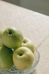 Glass vase with green apples.Fresh juicy fruits, vegetarian food.