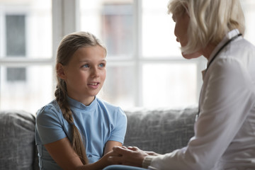 Focus on little girl holding hands aged therapist doctor