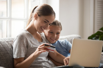 Mother and daughter using card paying money and buying online