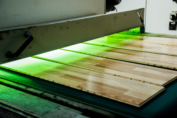 Production line of the wooden floor factory. CNC automatic woodworking machine.