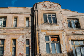 Old retro building weathered neglected facade closeup in sunny day