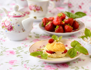 Profiteroles with strawberries on the summer table