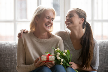 Happy middle aged mom and adult daughter celebrating Mother day