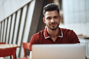 Fototapeta premium Adult man sitting in cafe with modern laptop