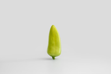 The pod of fresh juicy green bell pepper flies on a uniform white light background. Minimal concept, copy space. The idea of healthy eating