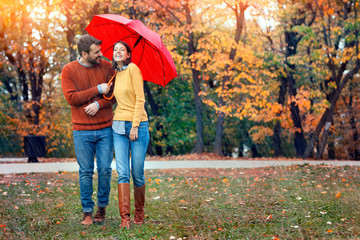 Naklejka premium Young couple man and woman walk under an umbrella