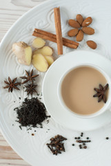 Traditional indian masala tea with spices in a white Cup and vertical orientation