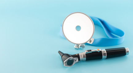 Ear professional instrument on blue background.
