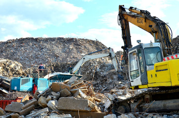 Excavator loads construction waste into reinforced concrete mobile shredder for crushing, recycling...