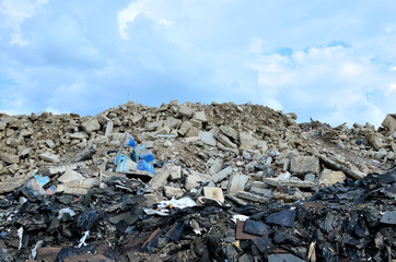 Fototapeta na wymiar Landfill of old stones and concrete slabs from destroyed buildings. Recycling, shredding, crusher and processing asphalt concrete, stones and rebar shredder. Secondary crushed stone, background