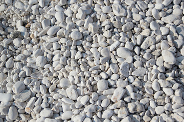 White pebbles of different sizes on the beach of Albania near the Ionian Sea