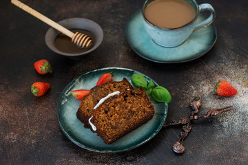 Two pieces of delicious honey cake with a Cup of coffee on a dark concrete background. Horizontal orientation
