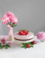Obraz na płótnie Canvas cake on a stand with strawberries on a background of flowers