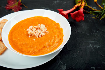 Cream of pumpkin soup on a black background.  Diet vegetarian pupmkin soup puree. Rustic. Thanksgiving Day.
