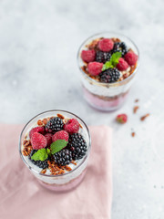 granola with chia yogurt and fresh berries on a light background top view