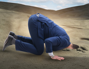 Businessman hiding his head in sand escaping from problems