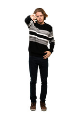 Fototapeta premium Full-length shot of Blonde man showing thumb down with negative expression over isolated white background