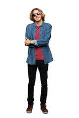 Full-length shot of Blonde man with glasses and happy over isolated white background