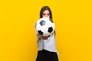 Young football player woman over isolated yellow background
