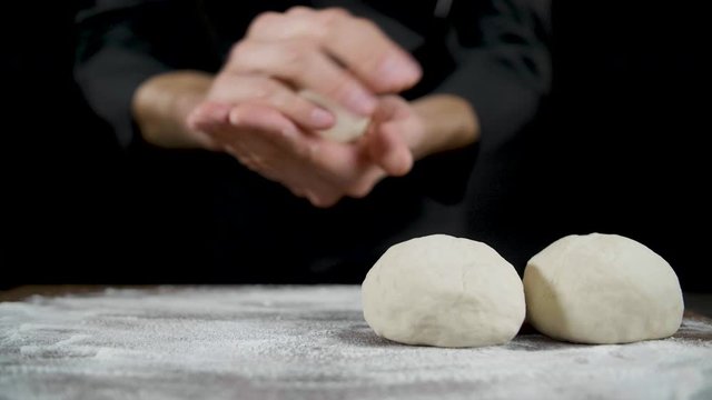 Chef makes scones from dough on a dark background