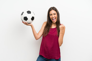 Young woman over isolated white background holding a soccer ball