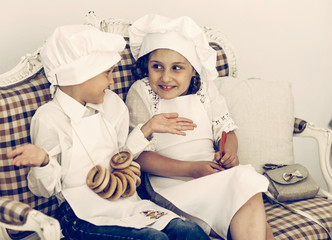 Portrait of happy brother and sister as a chef discussing recipe