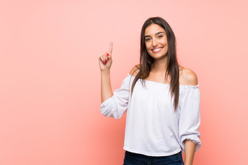 Young woman over isolated pink background showing and lifting a finger in sign of the best