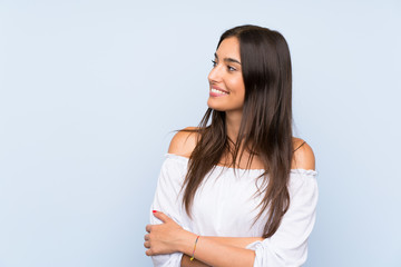 Young woman over isolated blue background looking to the side