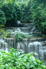 Fototapeta na wymiar A beautiful waterfall among the forest in Thailand. It is the best place for camping to feel fresh air, green leaves and peaceful nature during holiday. 
