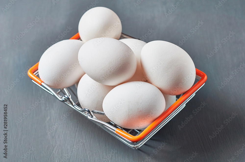 Wall mural Market basket full of eggs lies on rustic wooden table