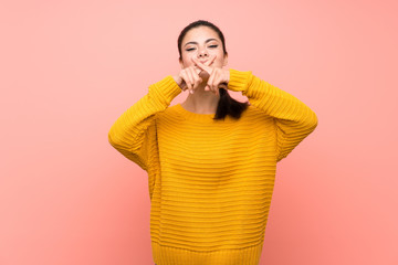 Teenager girl  over isolated pink wall showing a sign of silence gesture