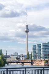 Beautiful and scenic overview of the famous landmark Berlin TV Tower during the day, with buildings on its side and the Spree river at the front view