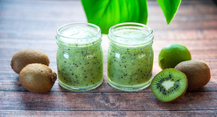 Kiwi smoothies in glass cups on a wooden table