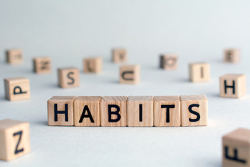 habits - word from wooden blocks with letters, Regular tendency or practice Routine, regularly acts concept, random letters around, top view on wooden background